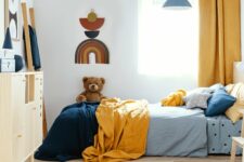 Teddy bear on single wooden bed in blue and orange bedroom interior